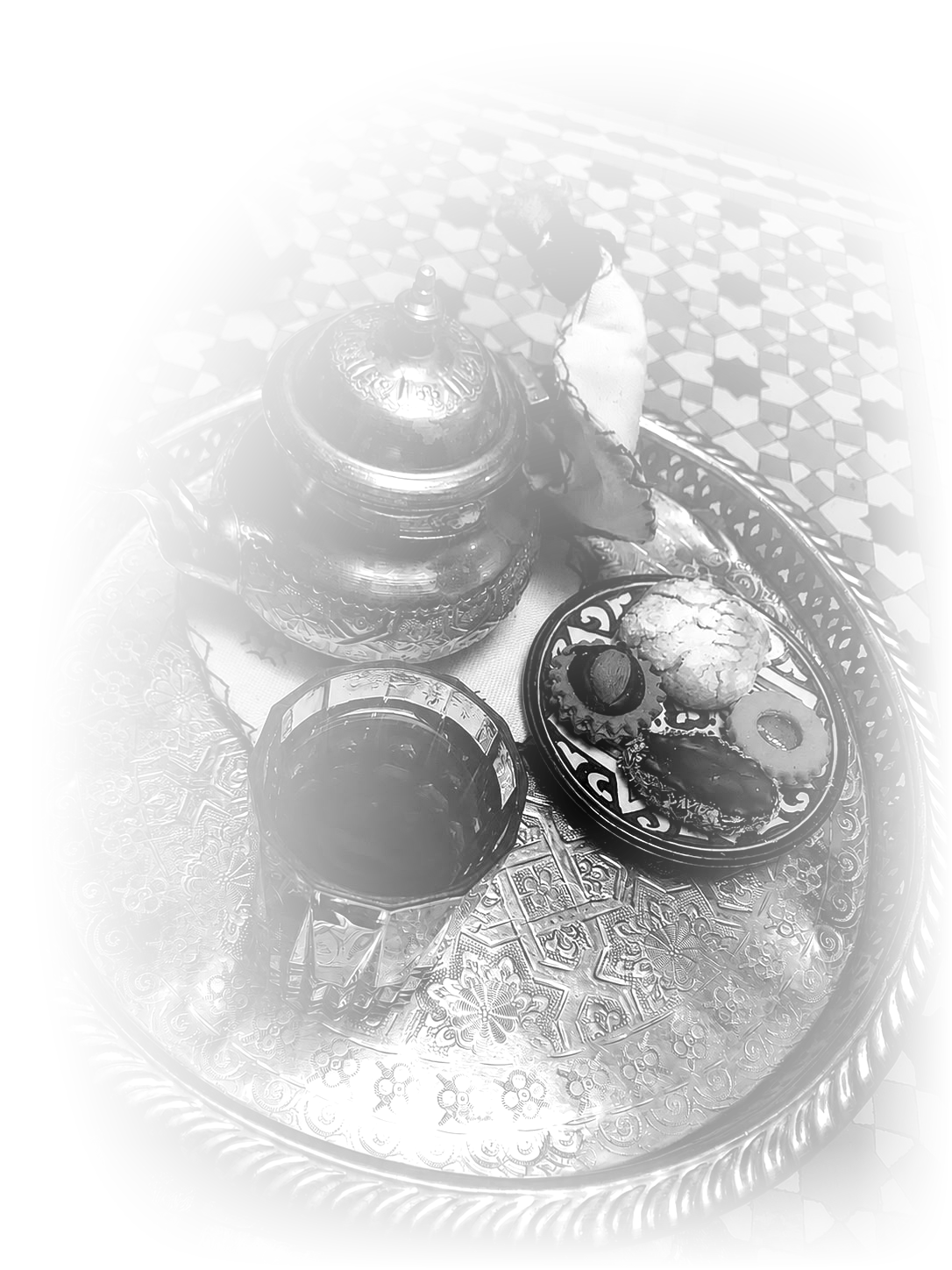 Moroccan mint tea and almond cookies on an engraved tray, black and white